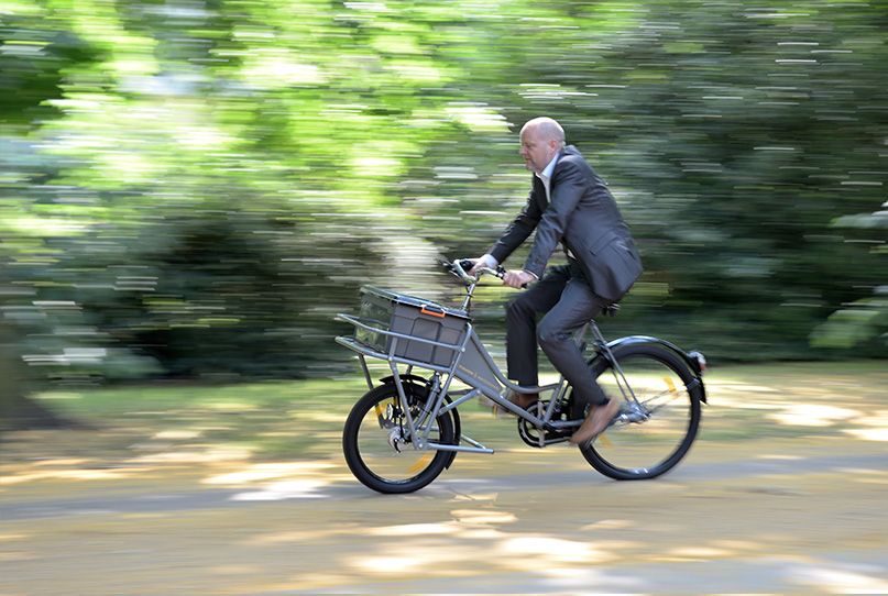 Ein Mann mit Anzug auf einem Fahrrad